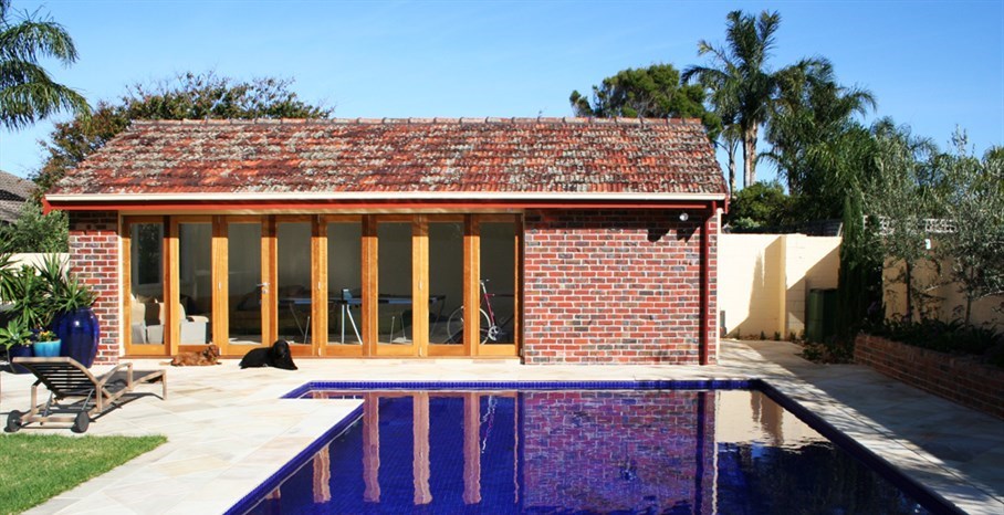 Surburban oasis garden in Melbourne, old garage converted into cabana with bathroom facilities and outdoor kitchen.  The existing pool was re-tiled and sandstone paving laid to match existing.  Large glazed terracotta pots placed to highlight focal areas from the main residence.  tropical pool landscaping, pool landscaping plants, landscaped pools, pool and landscaping.