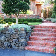 brick stairs, dry stone rock retainer wall, exposed aggregate driveway, turf, plant selection and planting, lighting